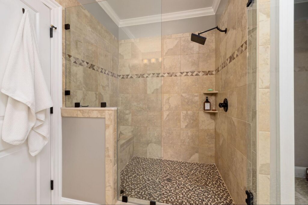 Tiled walk-in shower conversion with built-in bench and mosaic floor by Royal.